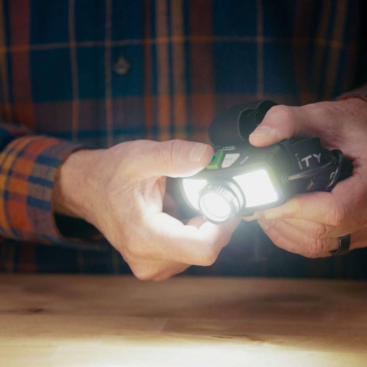 A man holding the Police Security Twin Power 1500 Headlamp while turning on the LED and COB lights to display its 1500 lumen output