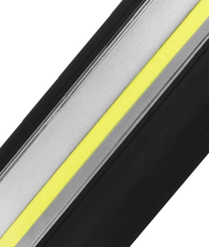 A close-up diagonal view of a rectangular LED light bar showing its internal layers: a black outer frame, a silver metal core, and a bright yellow reflective coating.
