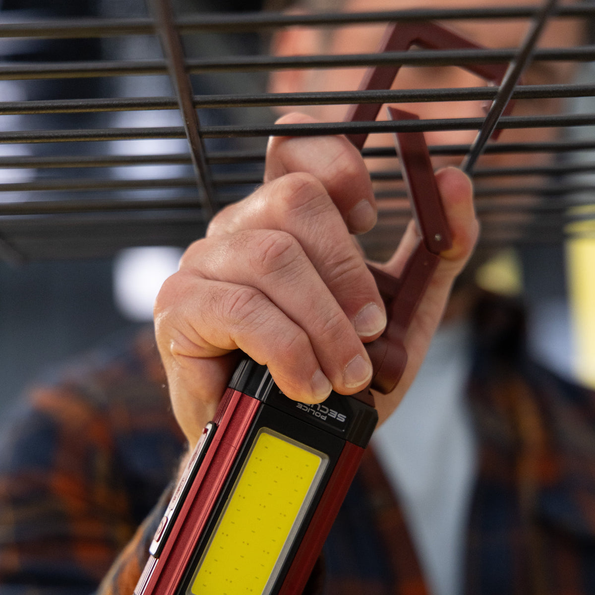 The carabiner hook of the Kickstand R Mini work light being used to hang it from a shelf