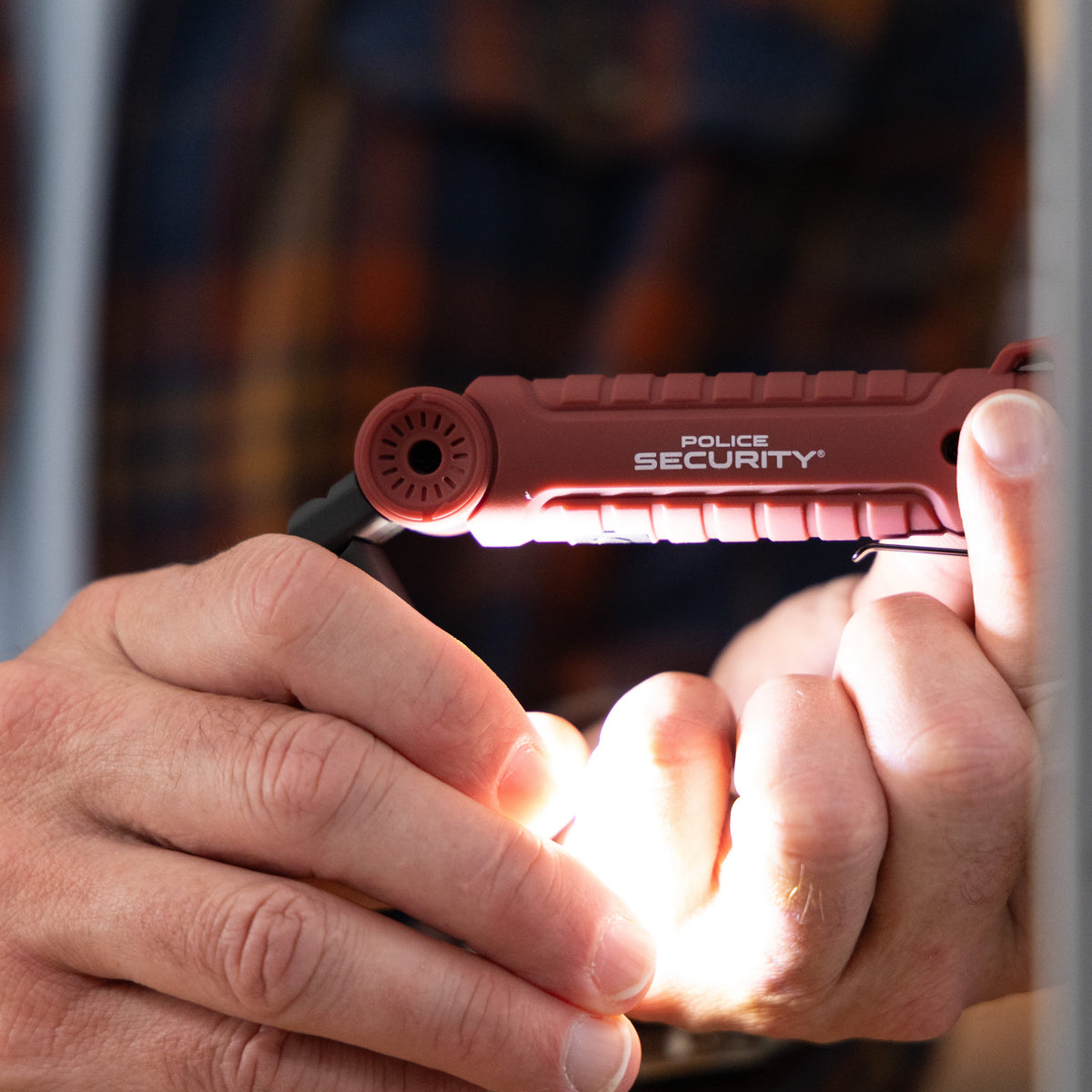 A Police Security ProFlex Mini Worklight attached to a metal surface with the magnetic tail cap