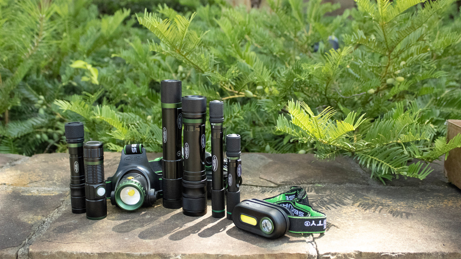 an image of the rechargeable headlamps and flashlights with bushes in the background