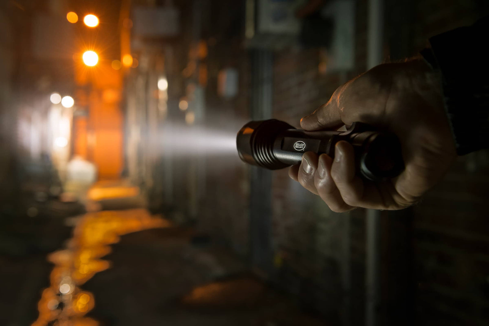 an image of a hand lighting the alleyway with a Police Security Flashlight