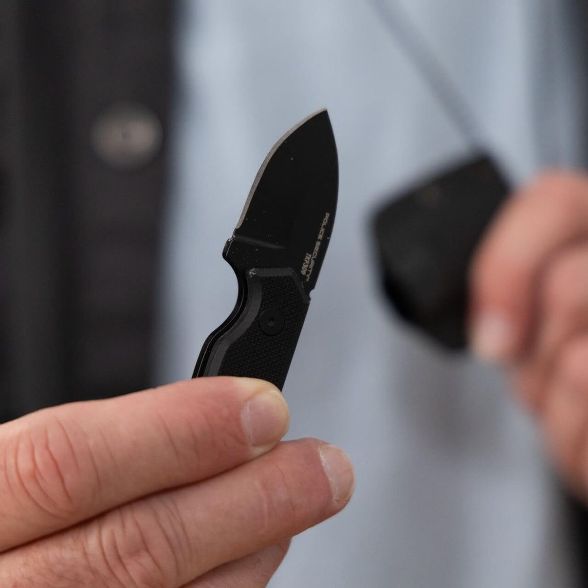 A man holding a small knife in his hand