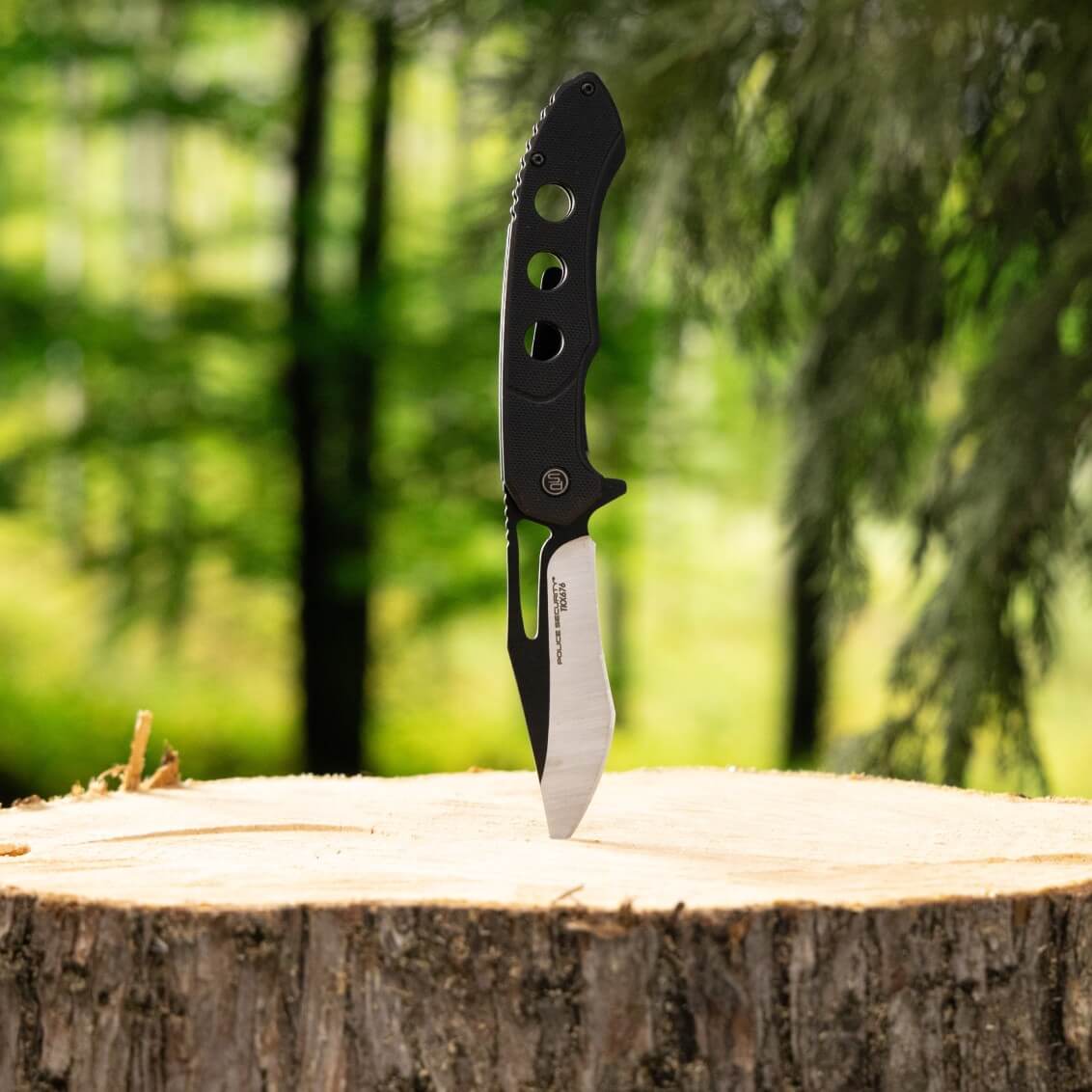 The TKX Pro pocket knife stabbed into a stump, showing the side of the knife