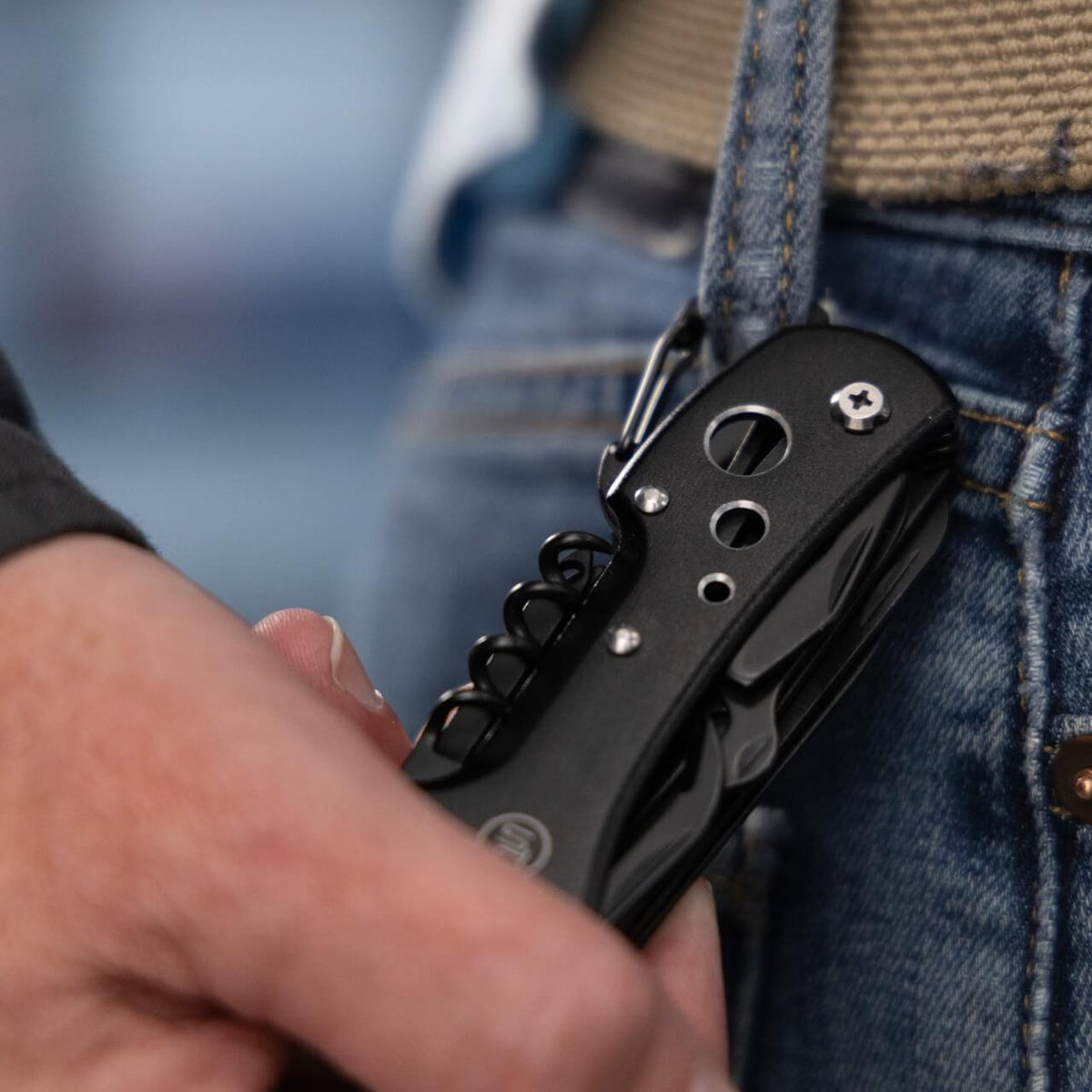A black Police Security Scout multi-tool clipped to a belt loop