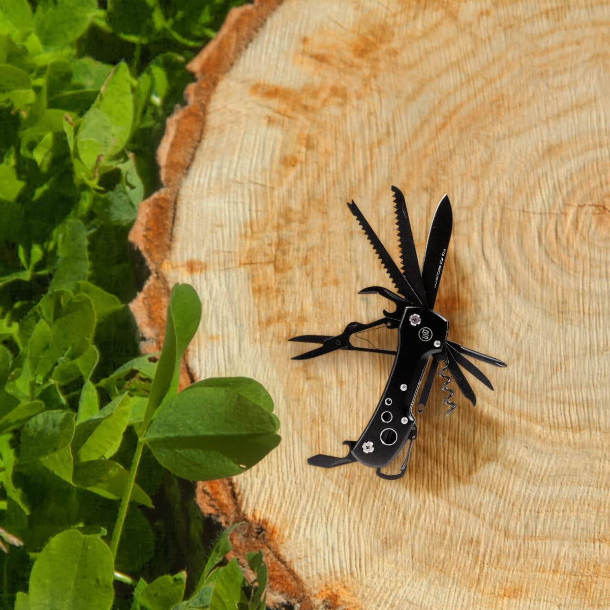 The Police Security Scout multi-tool pocket knife lying on a stump with clovers next to it