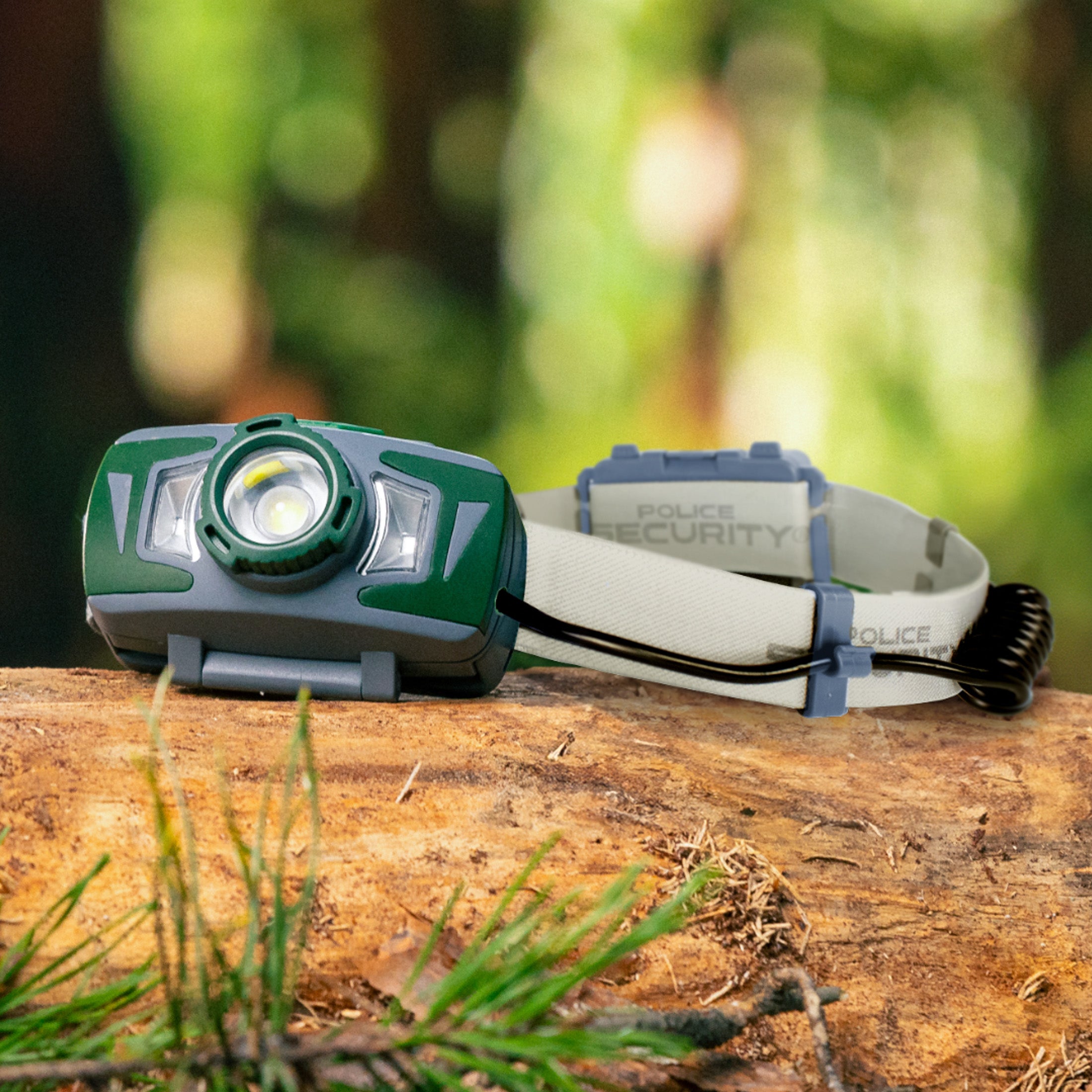 Police Security Twin Power headlamp on a log in the woods