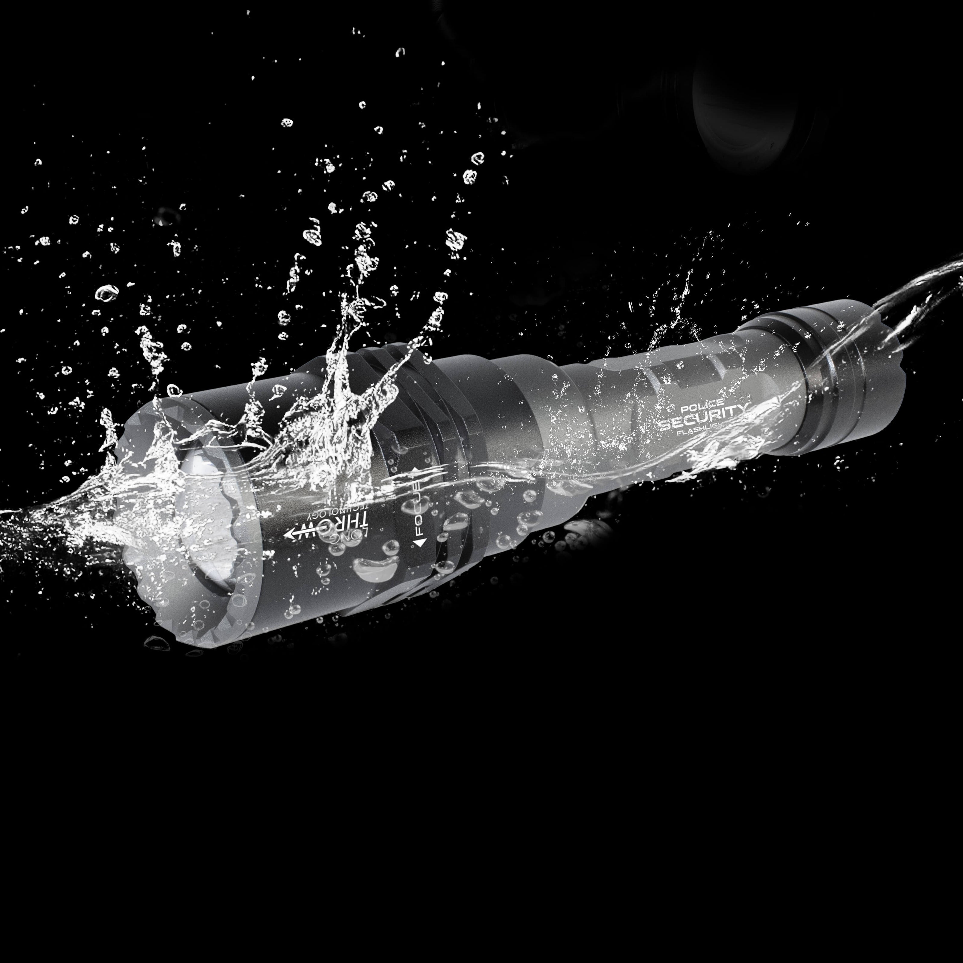 A bkack waterproof flashlight with white text, shown mid-splash through water against a solid black background.