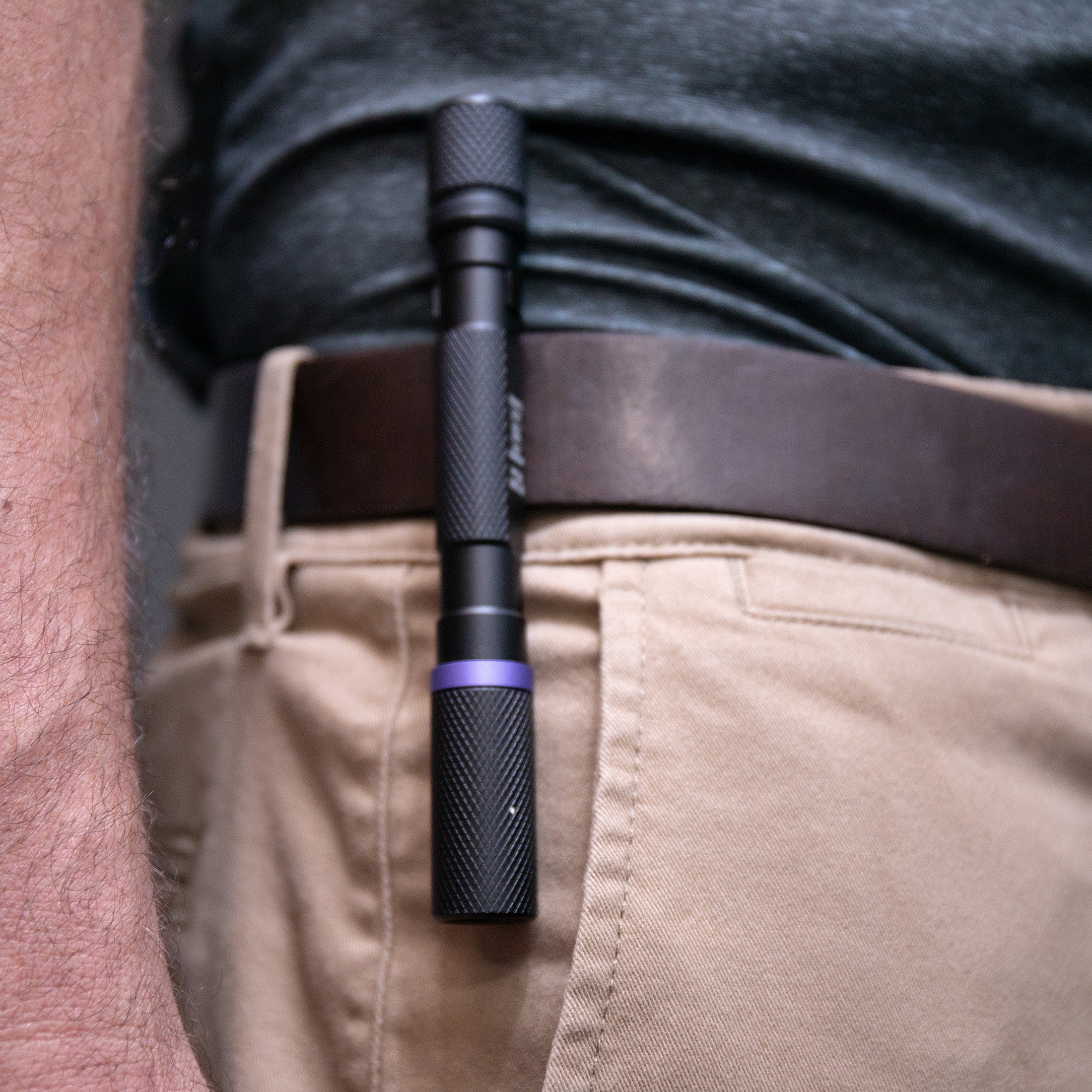 An image of UV FLASHLIGHT 6AAA clipped to a man's belt