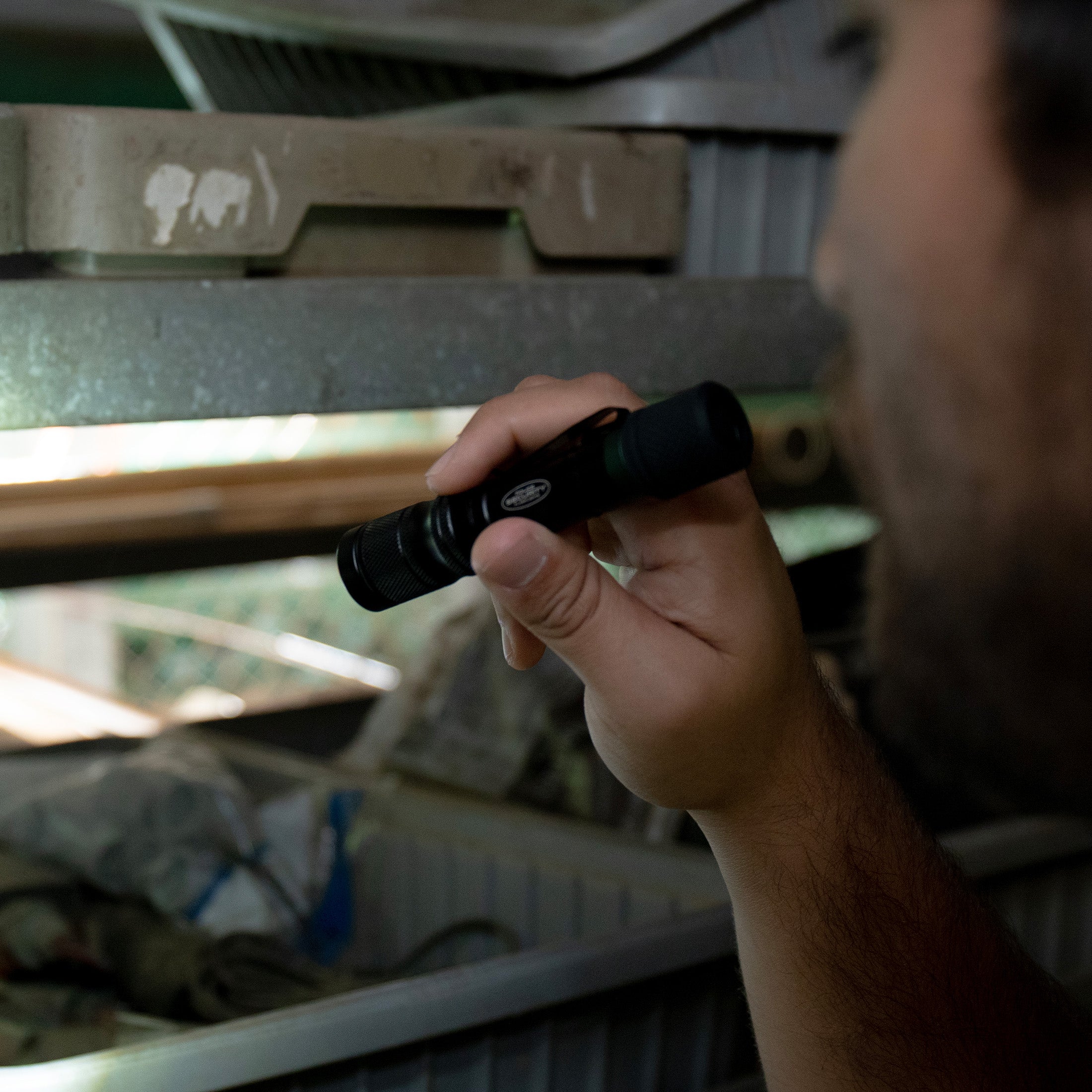 A man searching in dark boxes with the PROFLEX flashlight