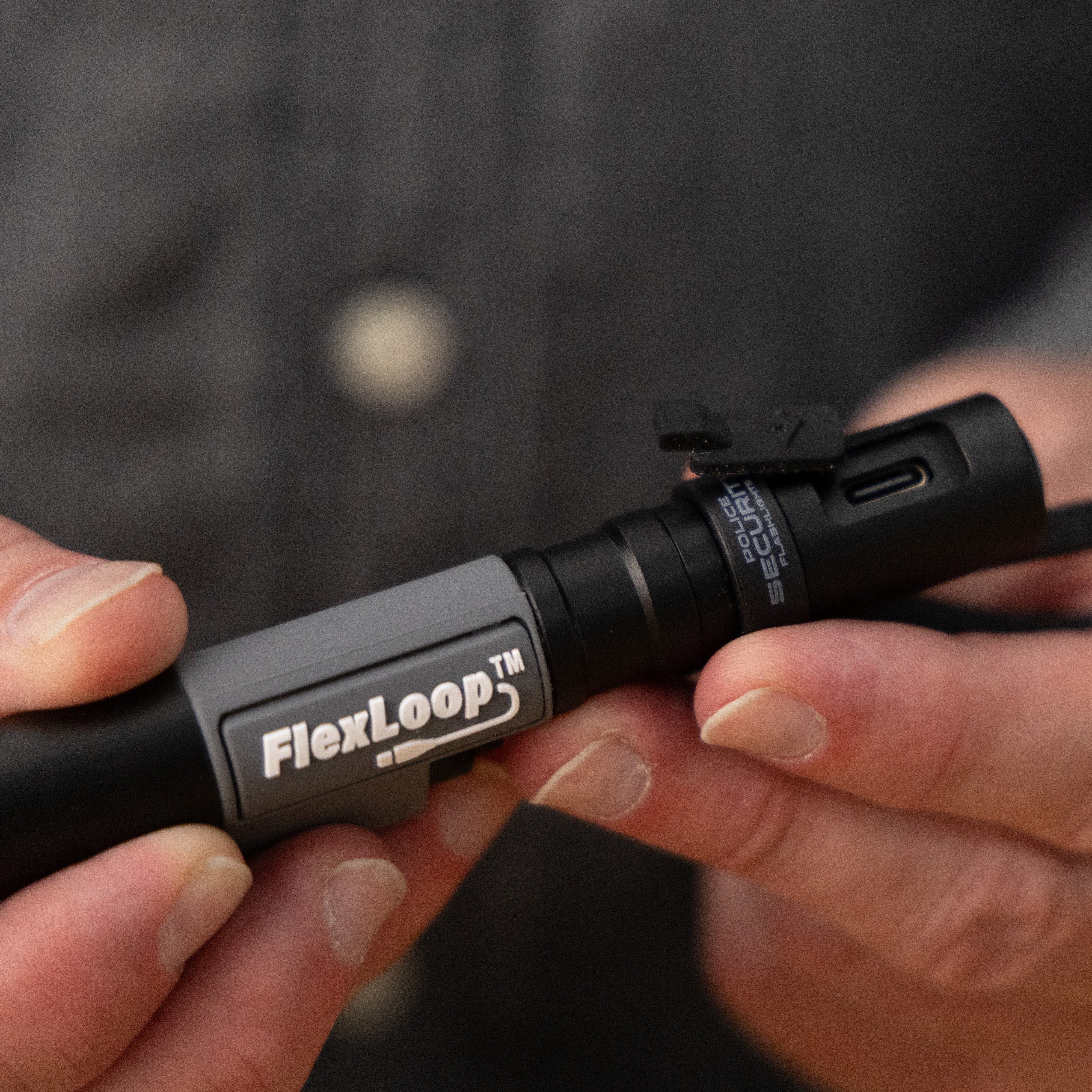 Person holding a FlexLoop flashlight with the charging port exposed