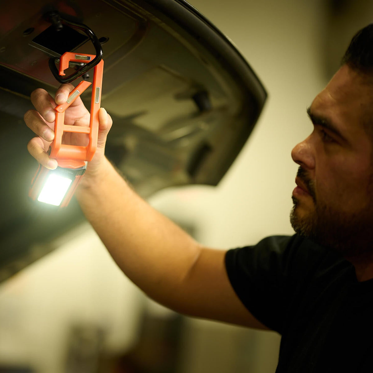 The carabiner clip of the Kickstand-R Mini used to hang it from the hook on a car hood
