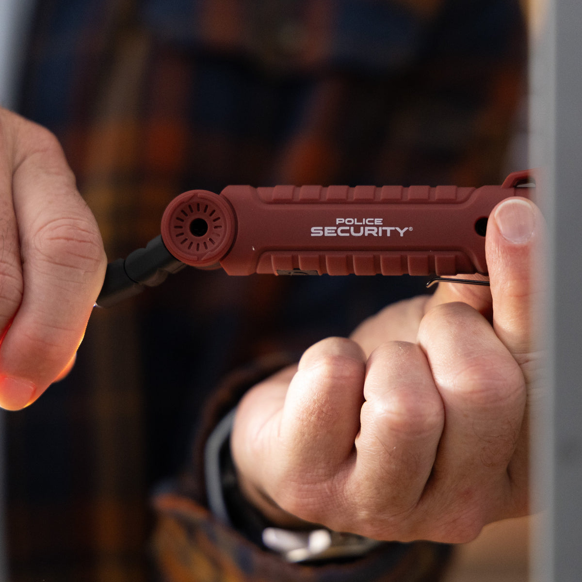 The Police Security ProFlex Mini worklight being attached to a metal wall