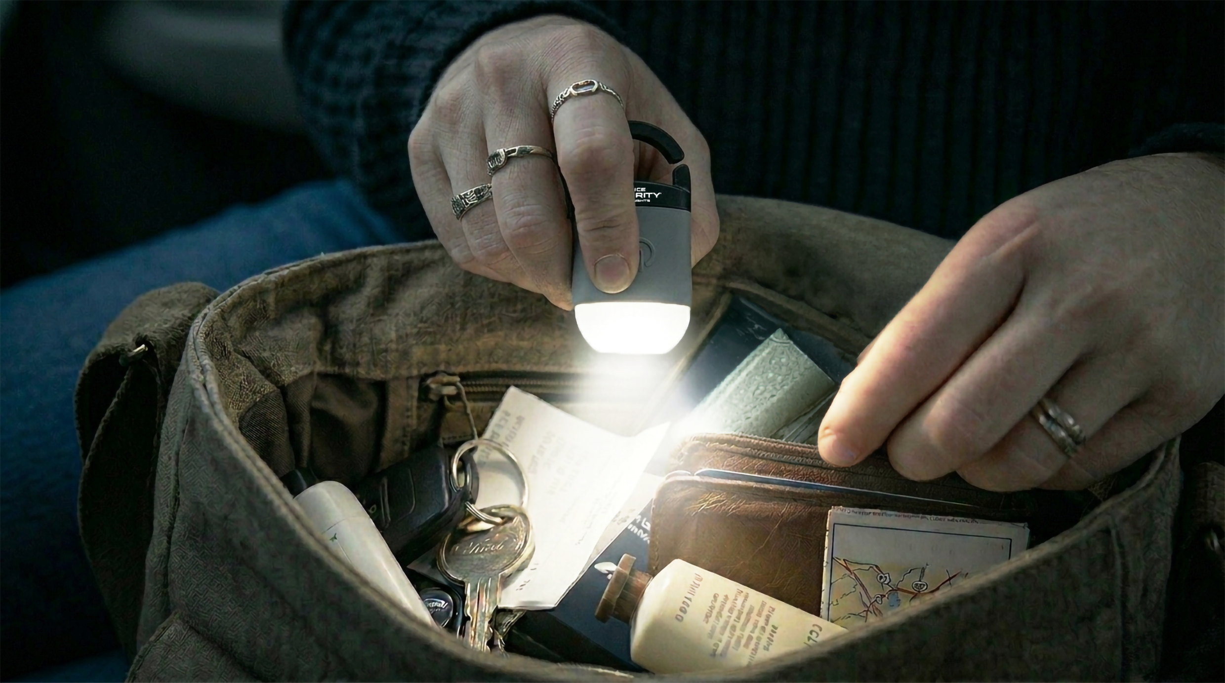Woman using Squeeze Light to find keys and a wallet inside her bag