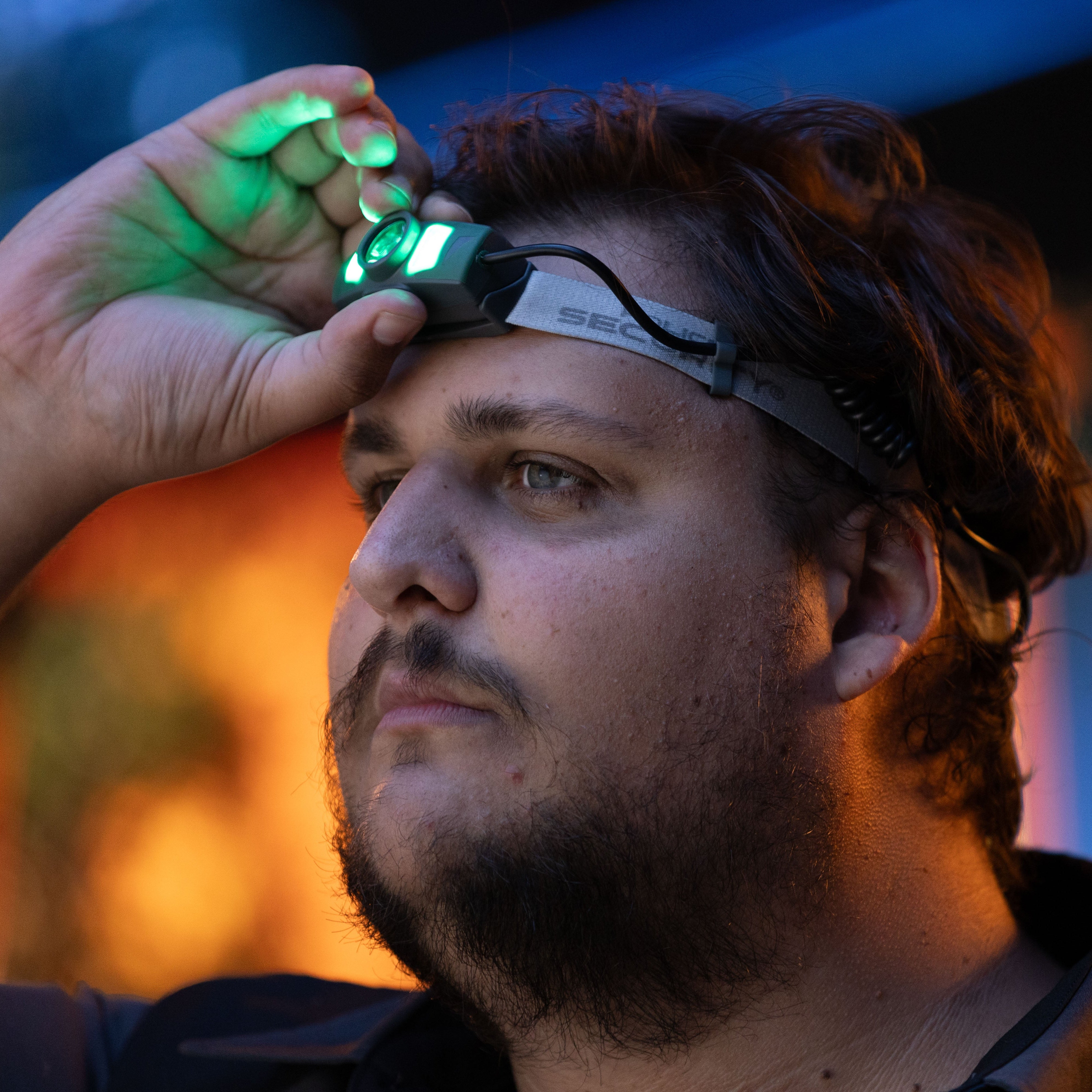 A man activating the green output on the Twin Power headlamp
